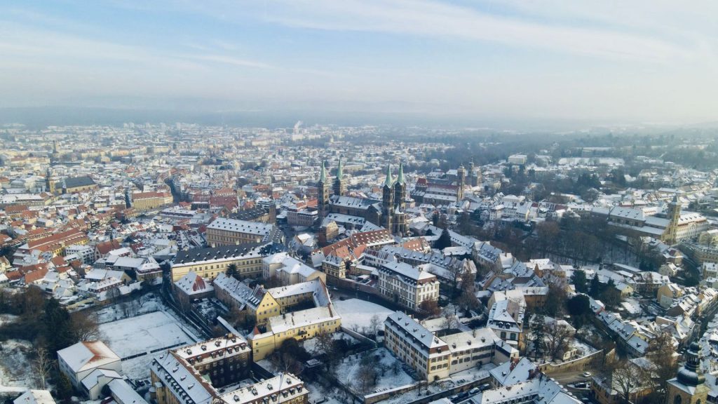 Une vue aérienne époustouflante de Bamberg, en Allemagne, recouverte de neige, présentant une architecture historique.