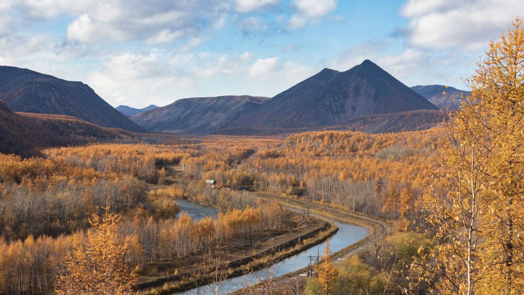 Diplomatie du Saint-Siège — vue aérienne époustouflante d'une rivière sinueuse à travers le feuillage automnal avec des montagnes