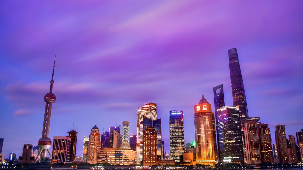 Une skyline vibrante des gratte-ciels modernes de Shanghai réfléchie dans l'eau au crépuscule.