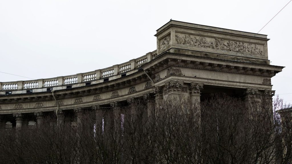 Maison de Moscou à Minsk — colonnade néoclassique en pierre avec bas-relief complexe, entourée d'arbres nus