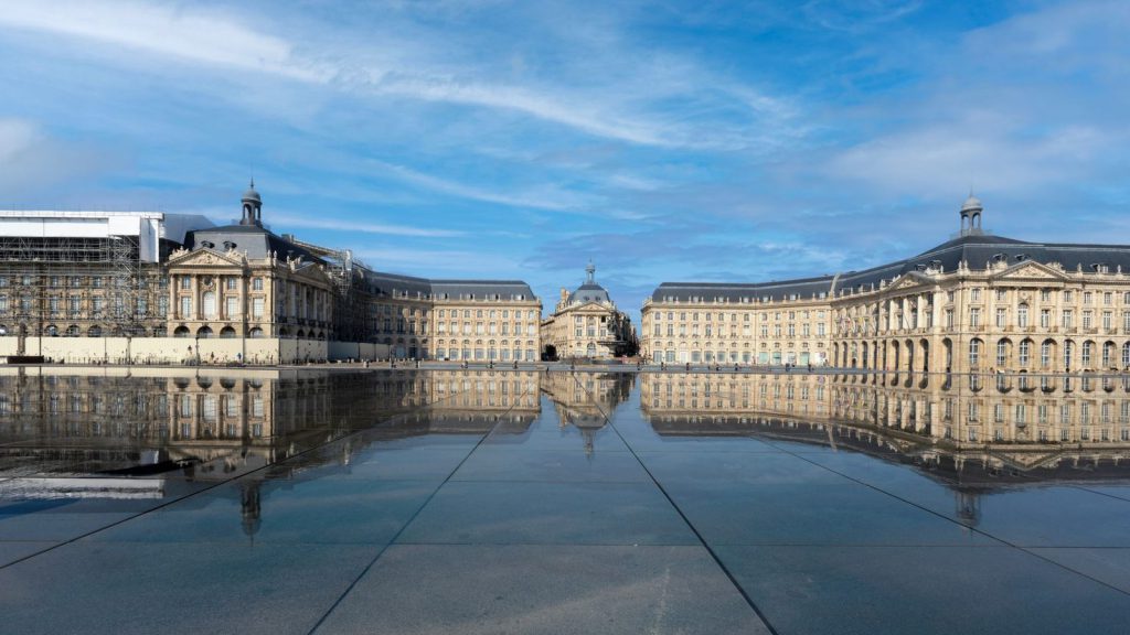 Interdiction du téléphone au lycée — superbe architecture néoclassique de la Place de la Bourse reflétée sur une surface d'eau calme à Bordeaux, France