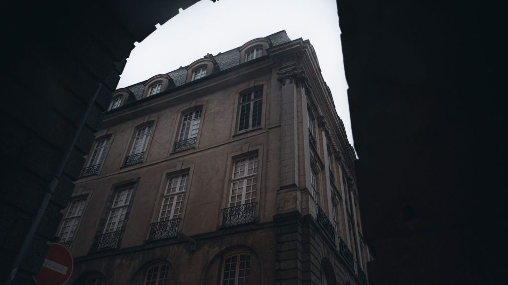 Usine d’équarrissage — vue dramatique d'un bâtiment européen classique au crépuscule avec des fenêtres illuminées