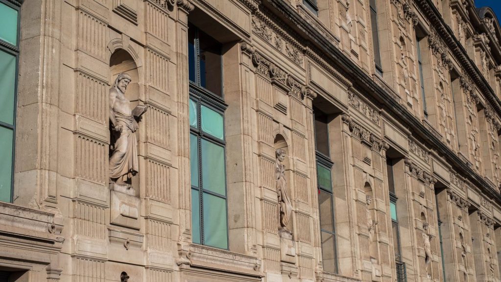Extrême droite en Bretagne — vue détaillée de la façade historique du musée du Louvre à Paris avec des sculptures