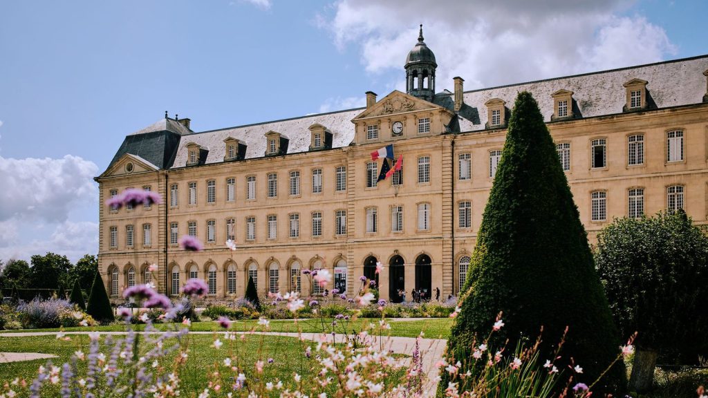 Télétravail hybride — vue imprenable sur l'Abbaye aux Hommes avec ses jardins vibrants à Caen, en Normandie sous un ciel bleu éclatant