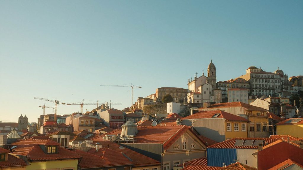 Assassinat de Daphne — vue panoramique de Porto, au Portugal, avec ses toits historiques et ses grues au coucher du soleil